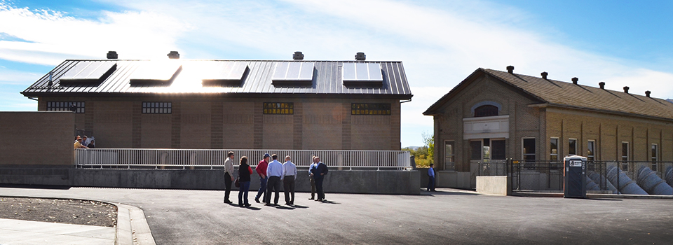 Men standing outside brick buildings at Utah Lake.