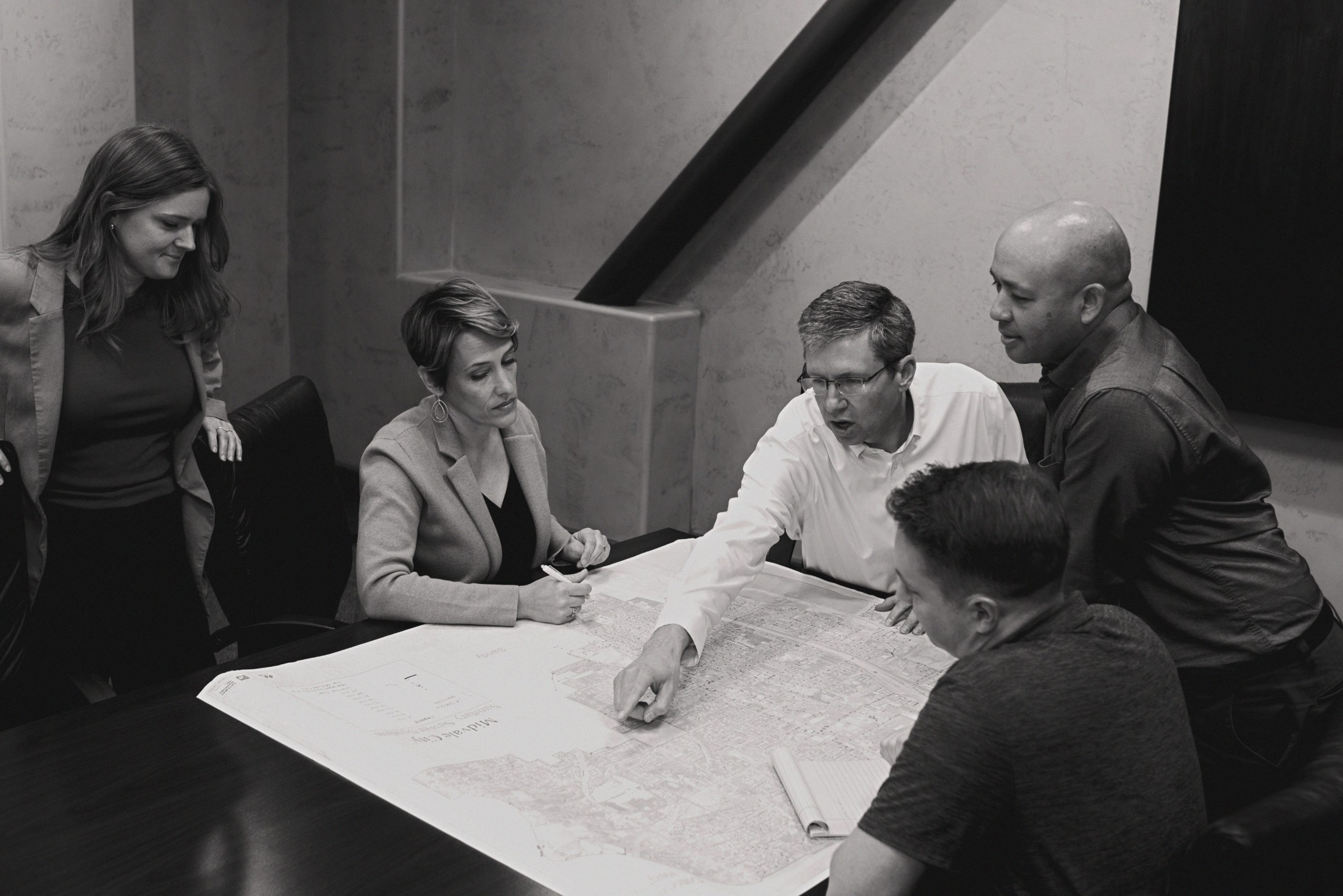 Colleagues discussing at a table over blueprints