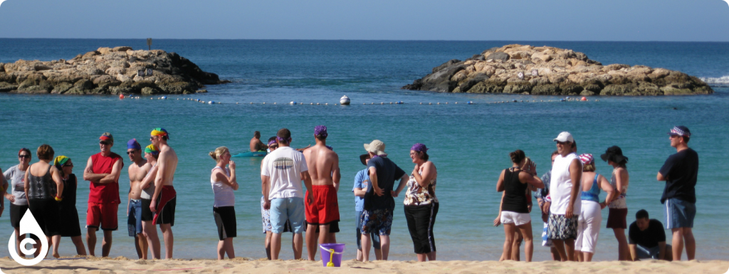 People standing on shore of a beach on a sunny day