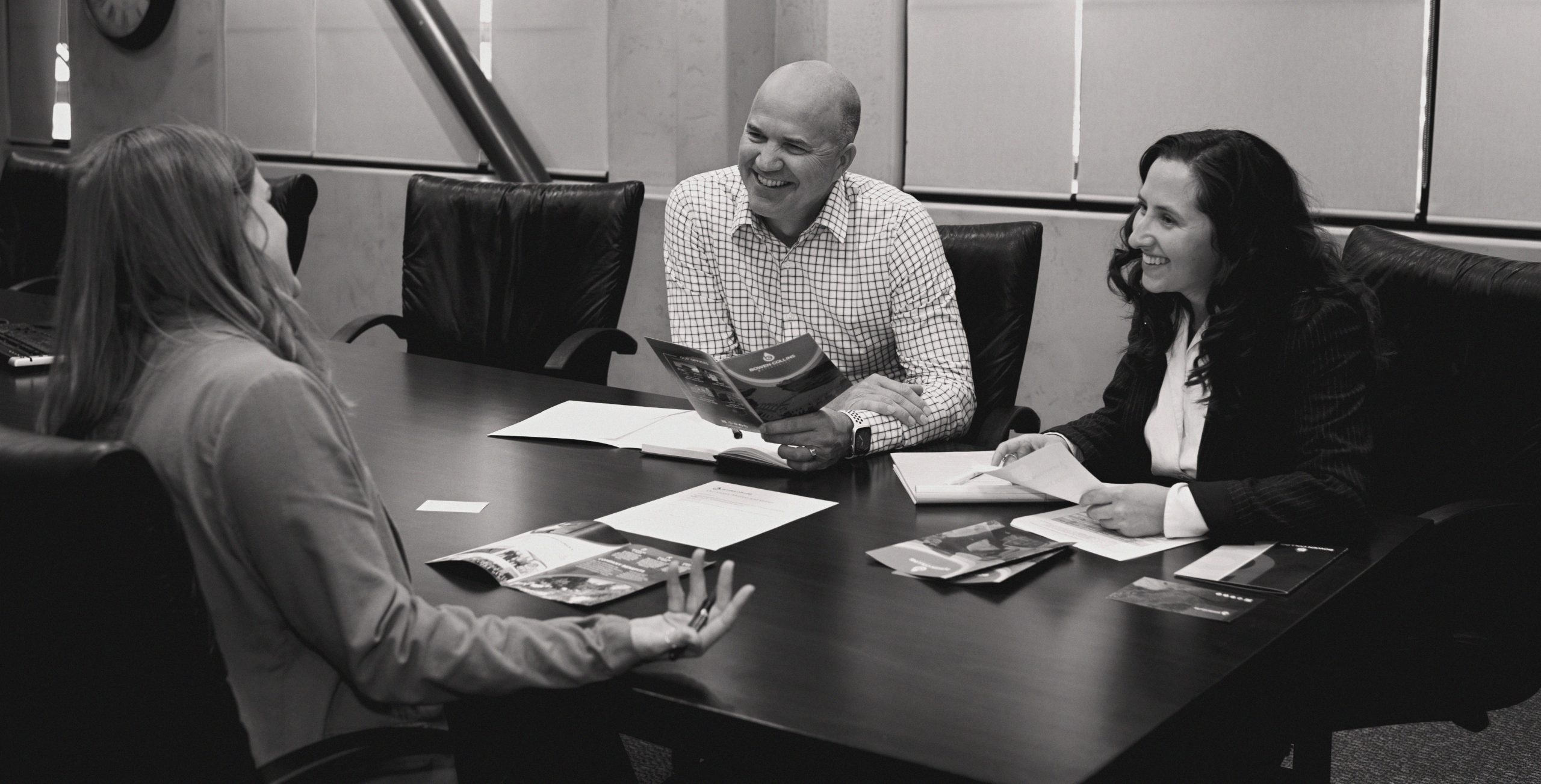 Colleagues laughing around conference table