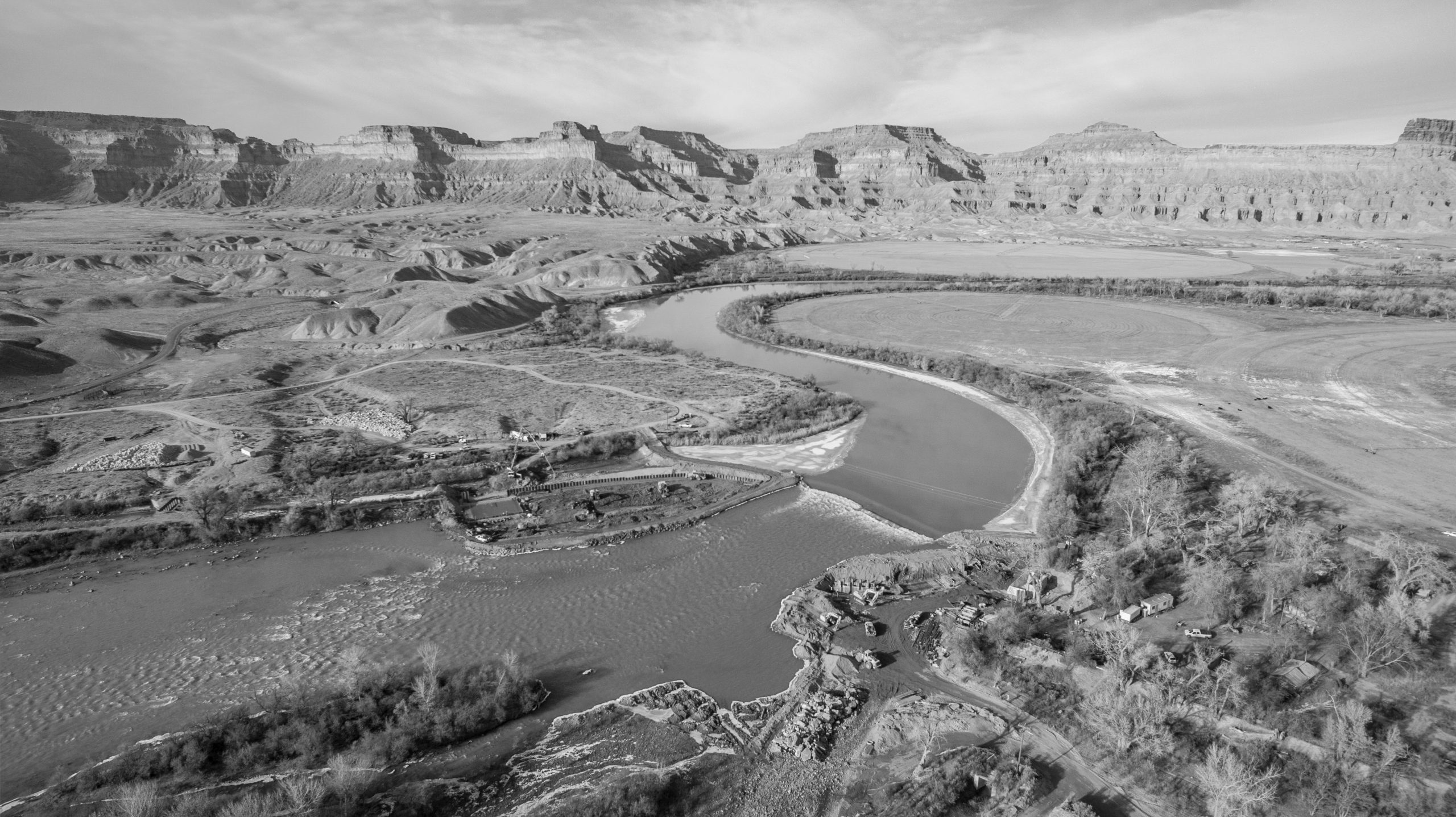 Aerial view of river winding through plateau landscape, in sepia tones